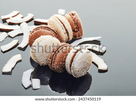 Close-up of two coconut macarons with flakes on gray background. Well-lit with vibrant colors, ideal for food blogs, recipe sites, and social media. Delicious and tempting treat for coconut lovers.