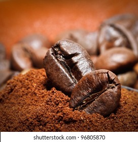 Closeup Of Two Coffee Beans At Roasted Coffee Heap. Coffee Bean On Macro Ground Coffee Background. Arabic Roasting Coffee - Ingredient Of Hot Beverage.