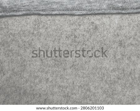 Close-up of two different gray fabric textures showing knit and felt materials side by side.
