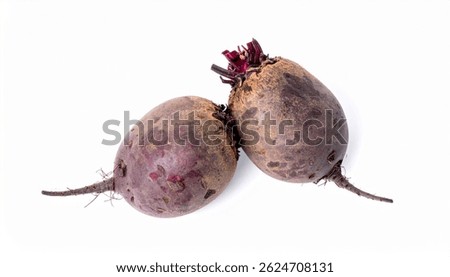 Closeup of two earthytoned beetroots, showcasing their roots and slightly textured skin. They are positioned on a plain white background.