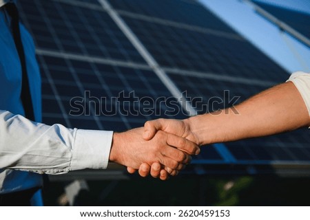 Close-up of Two Electrical Engineers shaking hands after working to inspect the installation and maintenance of solar panels in the solar power station