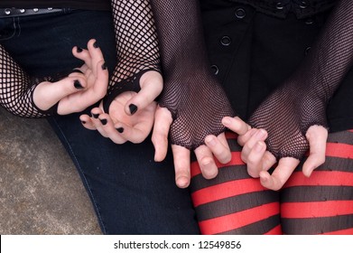 Close-up Of Two Emo Teen Girls' Hands, Wearing Fishnet Gloves