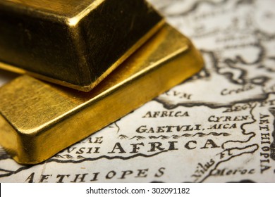 Close-up Of Two Gold Ingots On Top Of An Old Map Of Africa