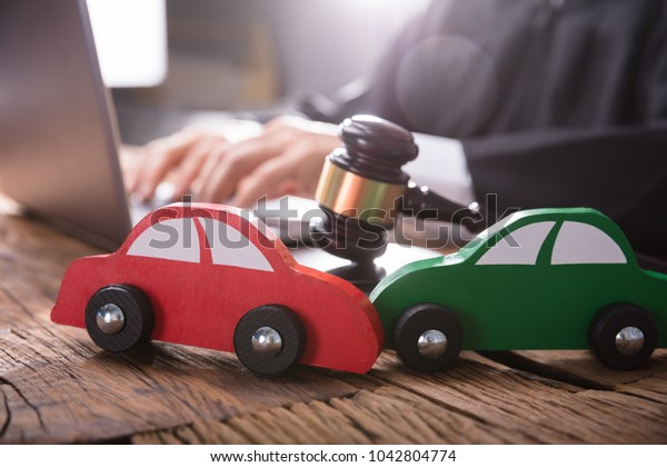 Close-up Of Two Green And Red Wooden Cars On
Desk In Courtroom