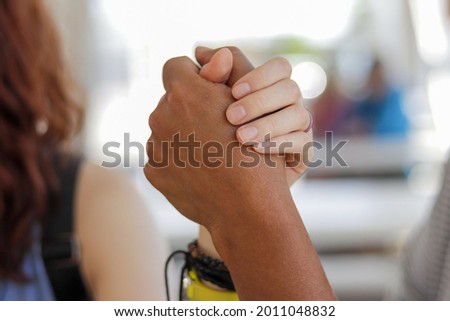 A closeup of two hands holding with a darker skin one of them - empowering concept