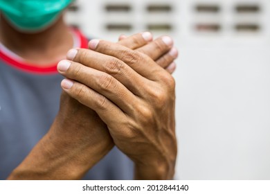 Close-up of two hands of a man squeezing in a massage due to nerve endings numbness in guillain barre syndrome, a possible side effect of the COVID-19 vaccination.