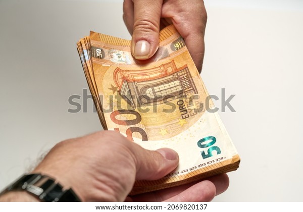 Close-up of two hands of people\
exchange a 50 euro notes to buy and sell. High quality\
photo