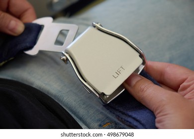 Closeup Of Two Hands Unfastening Seat Belt Inside The Plane