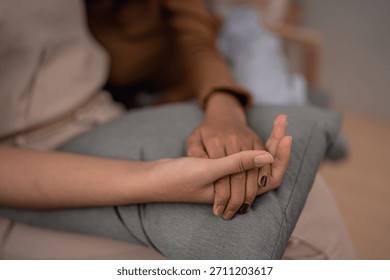 A closeup of two interlocked hands symbolizing connection and mutual support, showcasing a bond