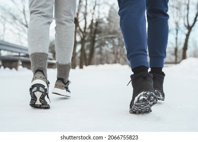 Close-up Of Two Joggers Feet During Winter Jogging In Snowy City Park