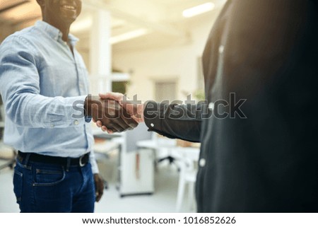 Similar – Image, Stock Photo Two young men shake hands. Close up of the hands in front of a green background.