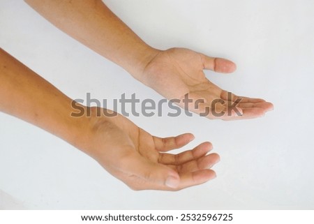 A close-up of two open hands facing upward on a white background, symbolizing giving, receiving, or offering. Ideal for concepts of help, generosity, and support.