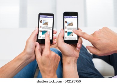 Close-up Of Two People Hands Chatting On Social Networking Site On Mobile Phones