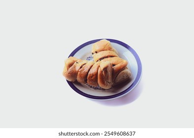 Close-up of two soft rolls filled with banana and chocolate served on a white ceramic plate. isolated white background
