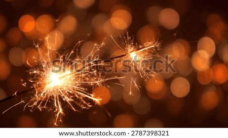 Close-up of two sparklers igniting, creating a dazzling display of light and sparks against a blurred background of warm, golden bokeh lights.