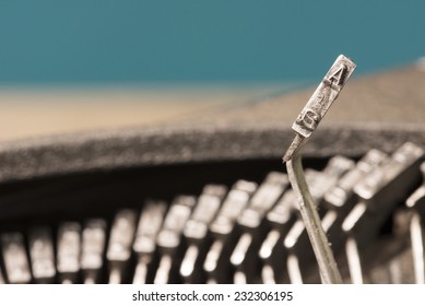 Closeup to typebars of an antique mechanical desktop typewriter with the letter A up