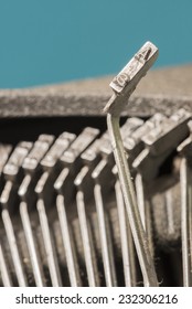 Closeup to typebars of an antique mechanical desktop typewriter with the letter A up