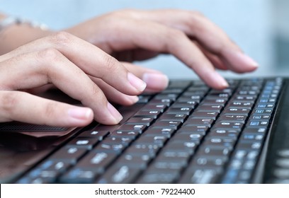 Close-up of typing on laptop keyboard of  female hands