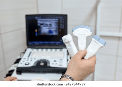 Close-up of ultrasound diagnostic probe. A doctor's hands hold a transducer for diagnosing internal organs using modern ultrasound technology, including elastography and sonography. - Powered by Shutterstock