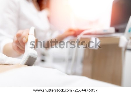 Closeup ultrasound scanner device in hand professional doctor woman use for examining patient female, sunlight.