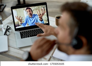 Close-up of uncertain businessman gesturing while having video call with a colleague over laptop. Focus is on computer screen.  - Shutterstock ID 1755053105