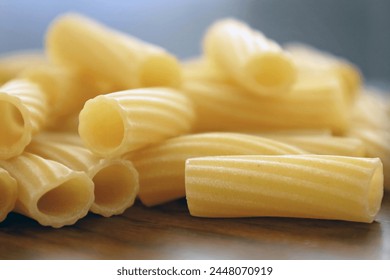 Close-up of uncooked rigatoni pasta on wood surface - Powered by Shutterstock