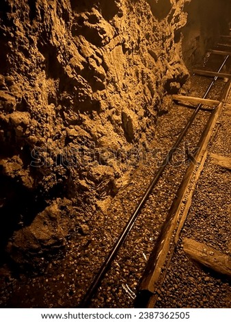 Close-Up of Underground Gold Mine Channel: Flowing Water, Stonework Walls Illuminated.