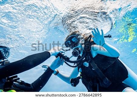 Close-up underwater view of a student and instructor scuba diving in a swimming pool during a training lesson