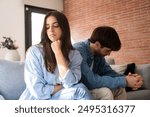 Close-up of unhappy young couple sitting apart have relationship problems, think about breakup or divorce. Family lovers, distraught men and women, avoid talking and suffer from betrayal in problems.