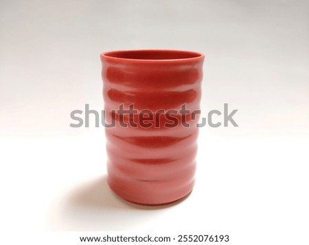 A close-up of a uniquely designed handleless glass, isolated on a clean white background, perfect for creative product showcases or minimalist desi
