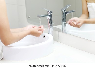 Closeup Of An Unknown Woman Washing Her Hands Under Running Water From A Tap Before Taking A Bath