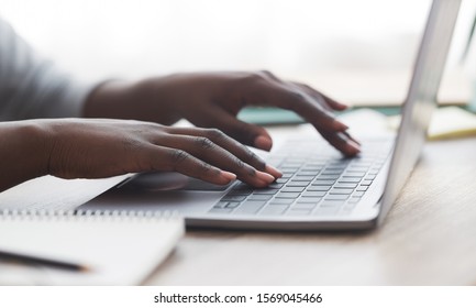 Closeup of unrecognizable afro woman typing on laptop keyboard while working in office, panorama