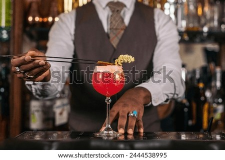 Similar – Image, Stock Photo Detail of a bartender opening a bottle of beer using a bottle opener at a bar counter.