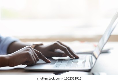 Closeup Of Unrecognizable Black Female Working On Laptop, Typing On Computer Keyboard While Working In Office, Side View, Cropped Image