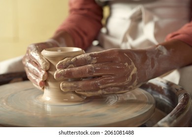 Close-up of unrecognizable black girl with wet dirty hands shaping clay vase on pottery wheel - Powered by Shutterstock