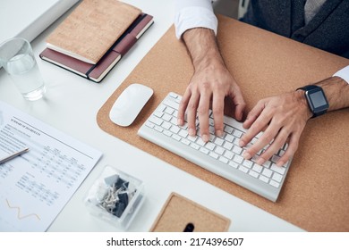 Close-up Of Unrecognizable Businessman Sitting At Table With Organizers And Papers And Typing On Computer Keyboard While Working On Business Project At Office Workplace
