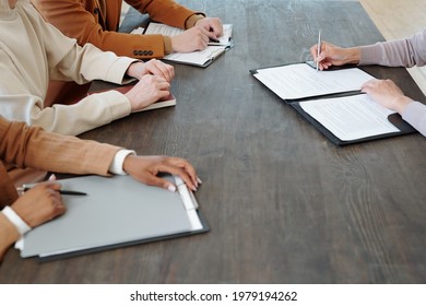 Close-up Of Unrecognizable Candidate Sitting At Table And Signing Document While Accepting Job Offer After Meeting With Recruiters