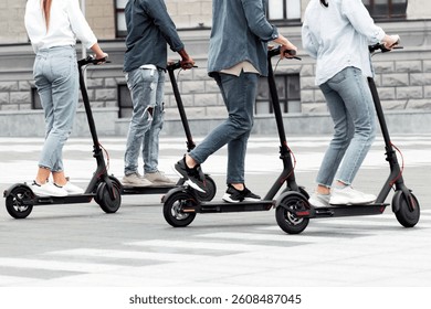 Closeup of unrecognizable diverse group of stylish teenagers riding motorized scooters in the city, panorama