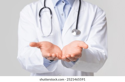 Closeup of unrecognizable doctor holding invisible object on his open palms, standing over white background, cropped image