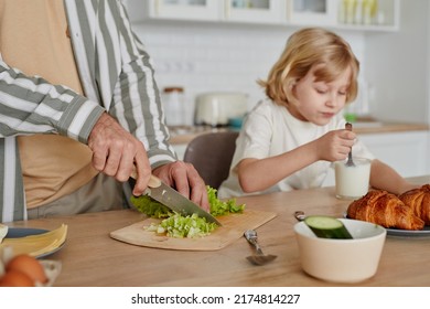 Closeup Of Unrecognizable Father Cooking Breakfast With Cute Boy In Background, Cozy Home Scene