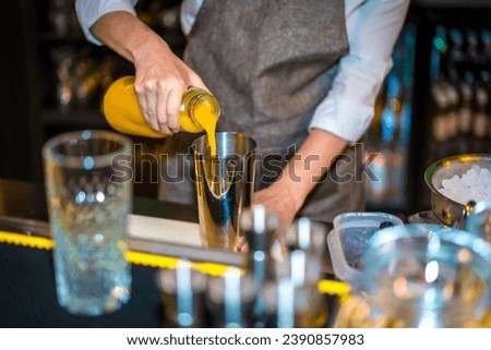 Close-up of an unrecognizable female bartender using juice to prepare a luxury cocktail
