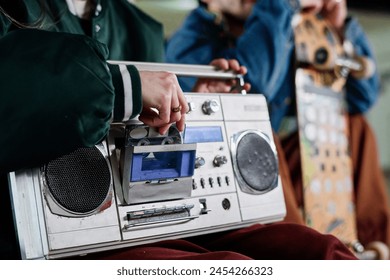 Closeup of unrecognizable girl inserting audio cassette into retro boombox to listen to music, copy space