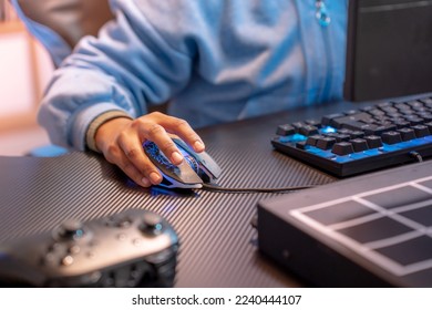 Closeup of unrecognizable hispanic woman hand clicking computer mouse game streaming online. High quality photo
