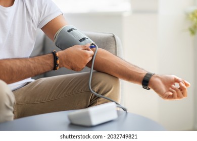 Closeup Of Unrecognizable Male Patient Using Modern Tonometer At Home, Panorama With Copy Space. Cropped Of Middle-eastern Man Measuring His Blood Pressure, Making Self Checkup