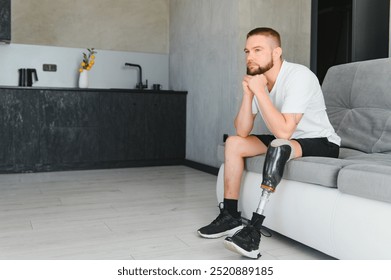 Closeup of unrecognizable man with bionic prosthetic leg at home indoors, copy space.