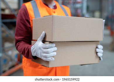 Close-up of unrecognizable warehouse worker carrying boxes while sorting it at stockroom - Powered by Shutterstock