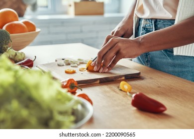 Close-up Of Unrecognizable Woman Cutting Veggies On The Kitchen Island