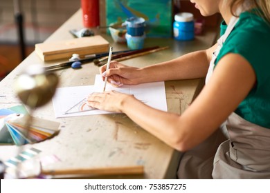 Closeup Of Unrecognizable Young Woman Drafting Sketch With Pencil For Art And Craft Project Sitting At Wooden Table In Workshop