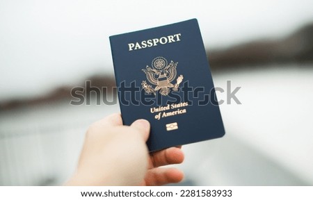 Close-up of a US passport with immigration, visa, citizenship, and travel paperwork on a wooden table