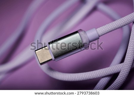 Close-up of a USB Type C connector cable for fast data transfer on a purple table.